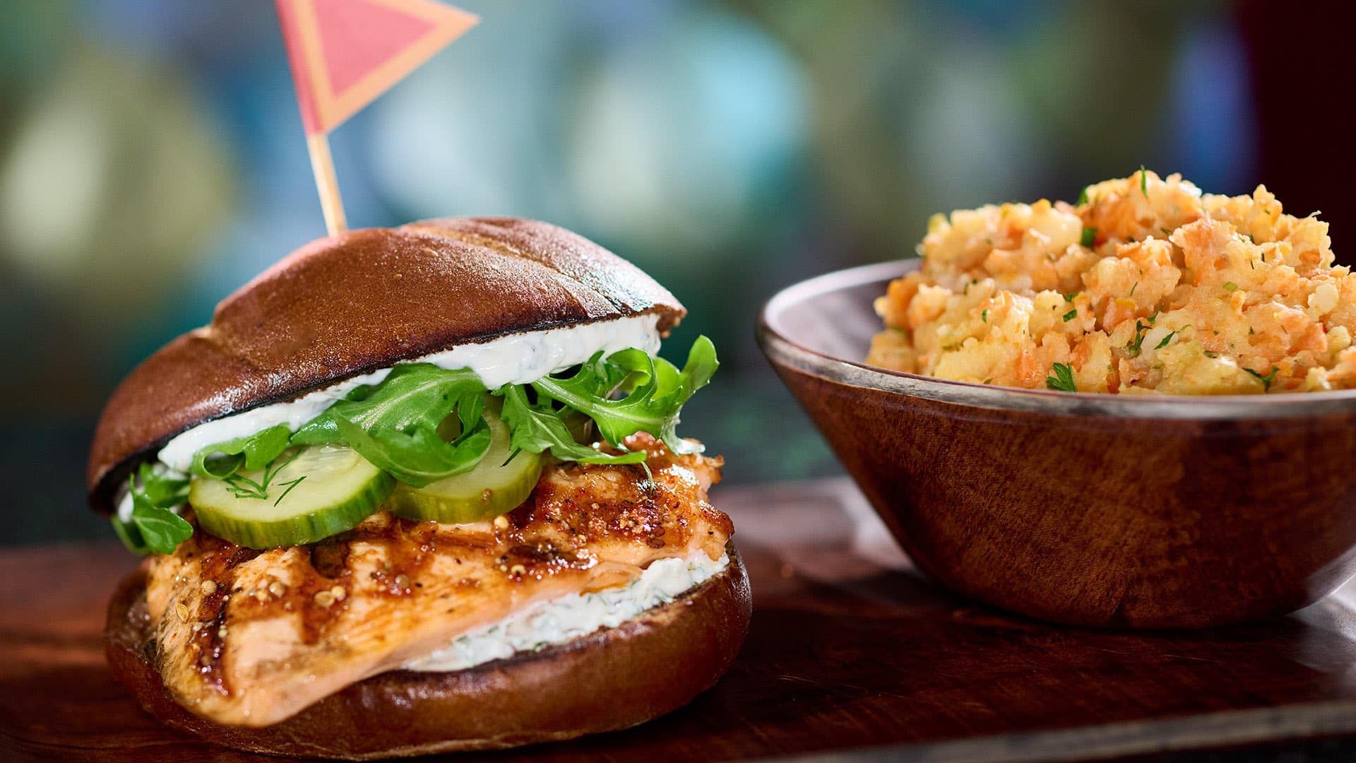 a burger and a bowl of snacks